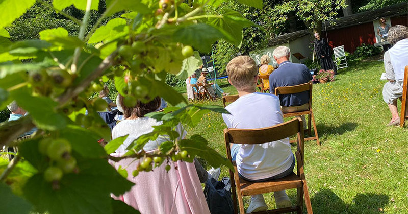 Menschen auf Klappstühlen im Garten